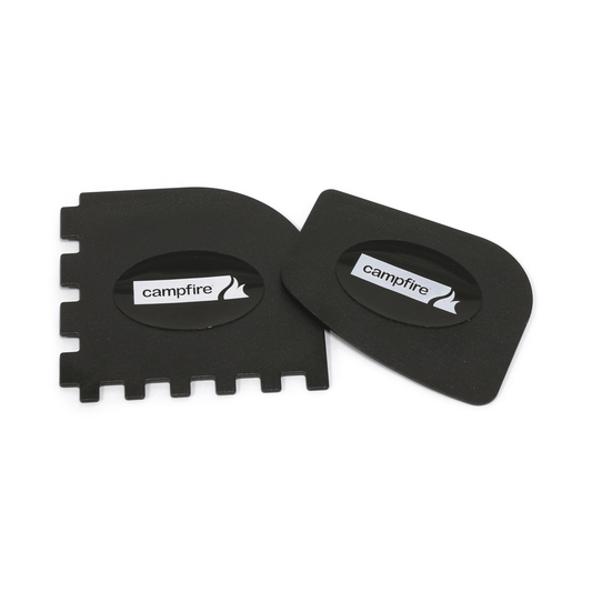 The Campfire Scraper Set 2PK includes two black plastic scrapers, one featuring square notches and the other a rounded edge—each with an oval label displaying the Campfire logo. Perfect for maintaining your cast iron cookware, these scrapers are ideal as pan or grill scrapers.