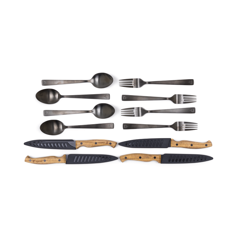 The Campfire 12pc Cutlery Set showcases four black stainless steel spoons and forks, complemented by three knives with elegant acacia wood handles and matching black blade covers, all beautifully presented against a white background.