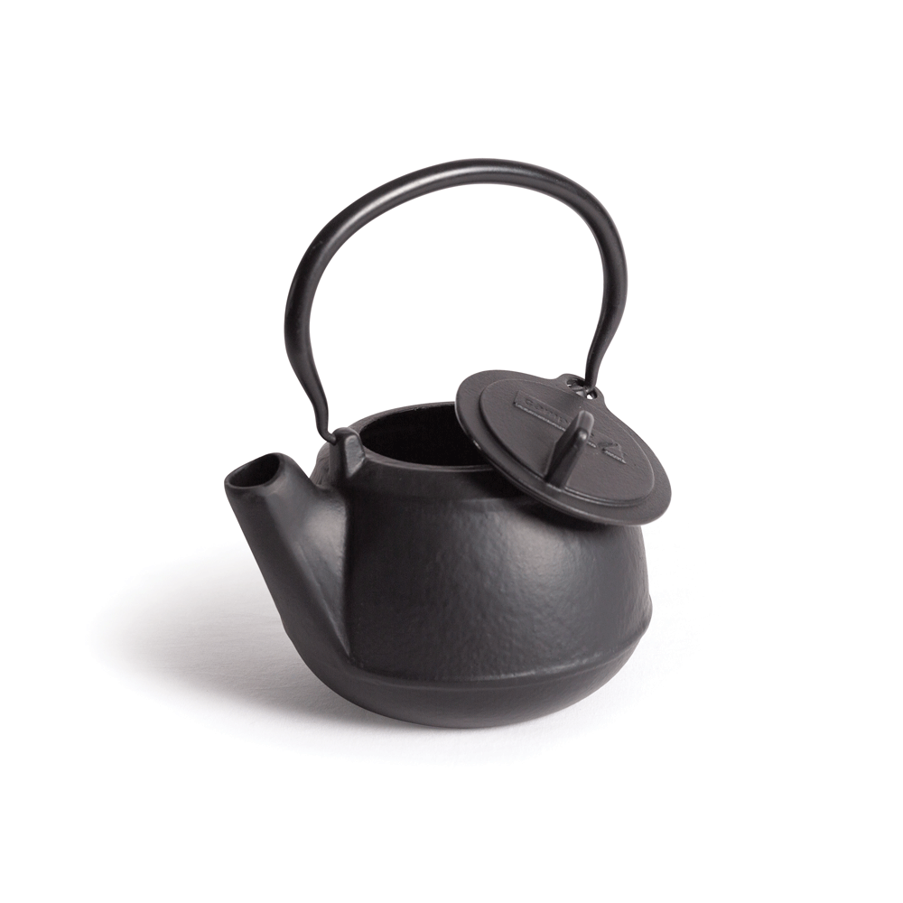 The Campfire 2 Quart Cast Iron Kettle, featuring a classic black finish, sturdy handle, and partially open lid, is displayed against a white background.
