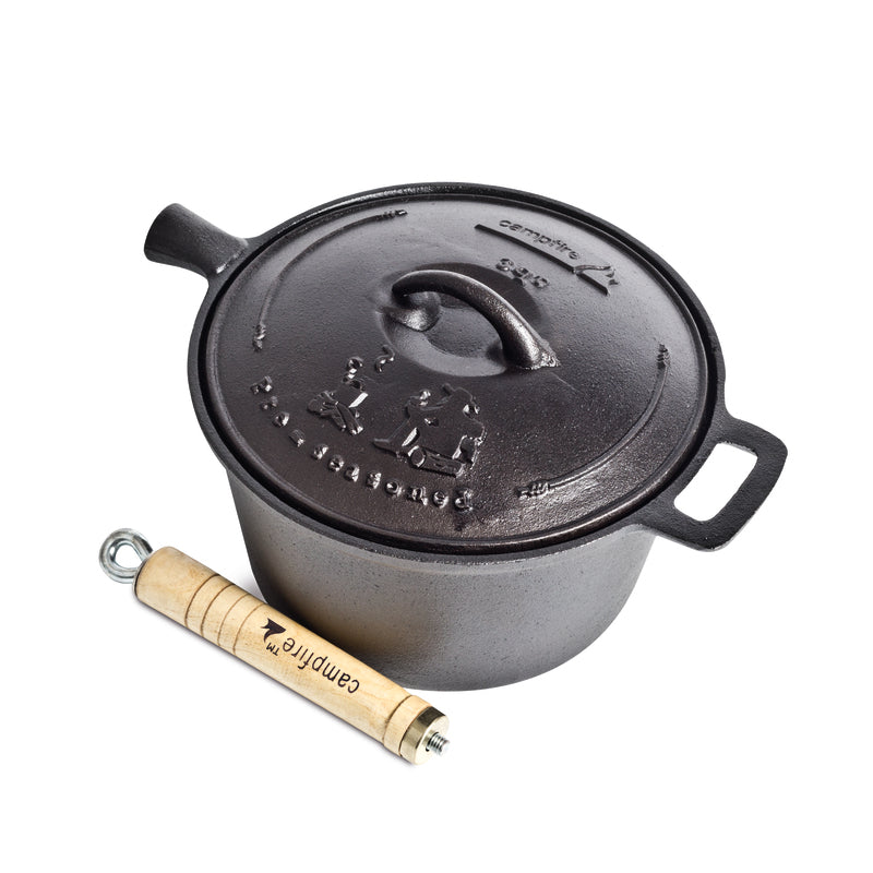 A black 3 Quart Cast Iron Saucepan by Campfire is shown next to a wooden-handled lid lifter labeled "Campfire." Renowned for its exceptional heat retention, this saucepan features embossed designs and text on the lid. The removable wooden handle on the lid lifter ensures safe and comfortable use around the campfire.