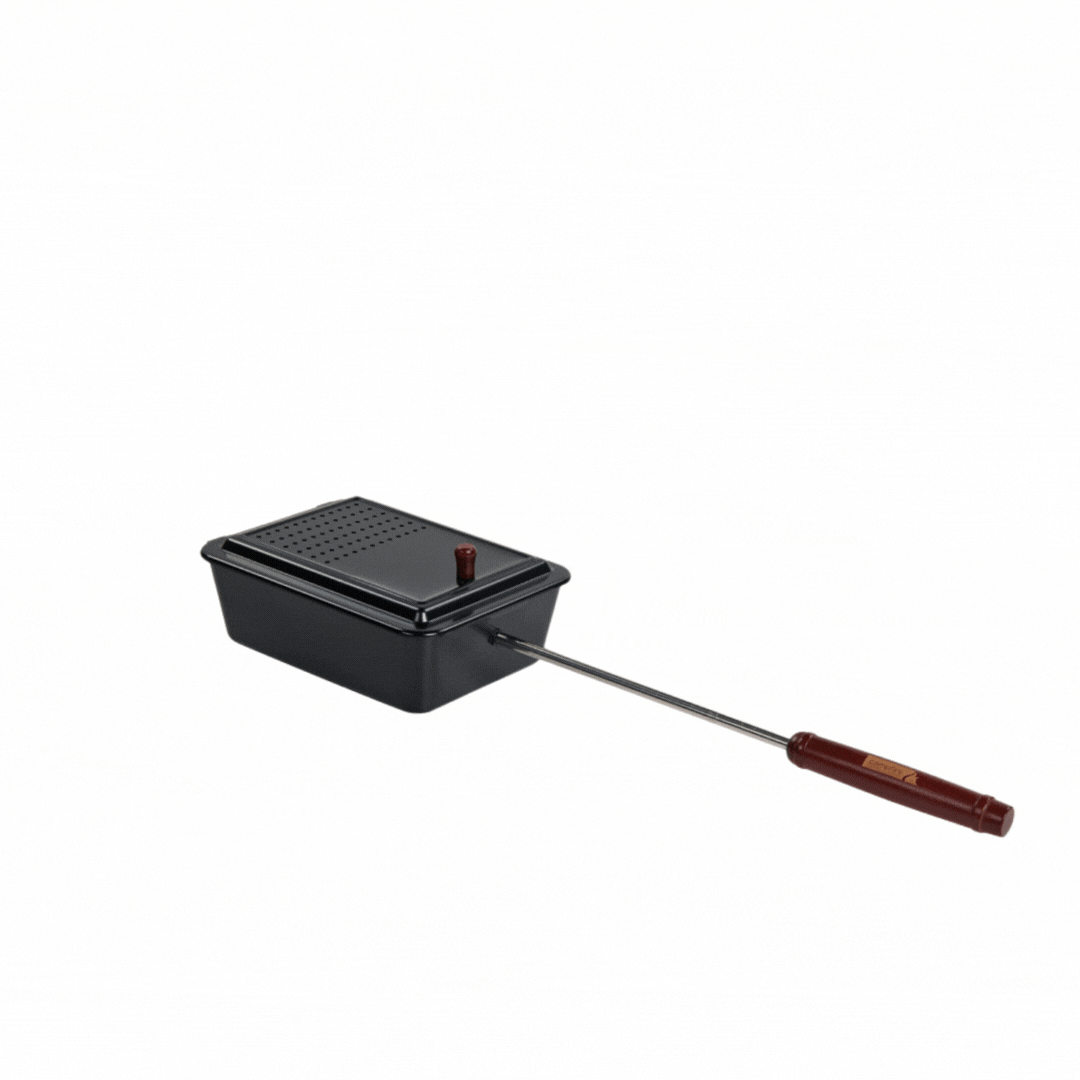 The Campfire Popcorn Pan, featuring a black metal design with a hinged lid, vent holes, and an extended metal handle with a wooden grip, is ideal for making fire-popped popcorn during campfire cooking—shown isolated on a white background.