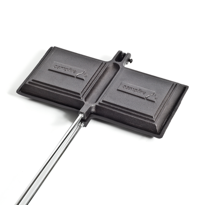 The Campfire Jaffle Iron Jumbo Double features long metal handles and a durable cast iron body, making it perfect for grilling sandwiches over an open flame and creating delicious campfire meals.