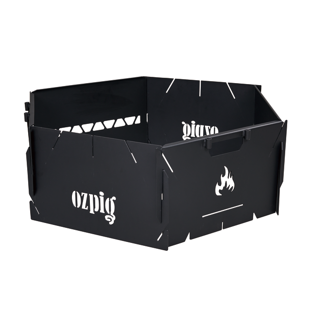 The Ozpig 3-in-1 Flat Pack Fire Pit features a black metal hexagonal wind guard with a cutout flame design and interlocking panels, ideal for portable use.