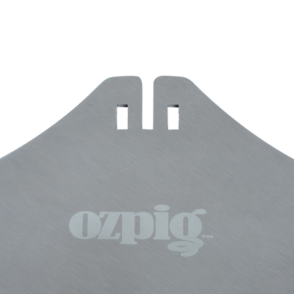 Close-up of a metallic surface with two rectangular notches and "ozpig" printed in white lowercase letters, part of the Ozpig Kebab Rotisserie Set featuring durable stainless steel skewers from Ozpig.