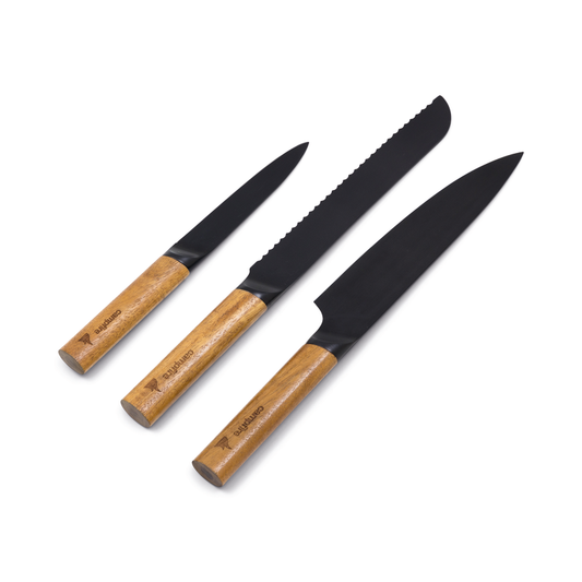 The Campfire 3pc Premium Knife Set features a paring, bread, and chef’s knife with acacia wood handles and black blades, arranged side by side on a white background.