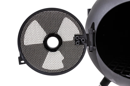 A close-up shows a round metal door with a mesh screen and radiation hazard symbol, attached to the Ozpig Series 2 Portable Wood Fire Stove by Ozpig. The open door reveals its empty interior—ideal for backyard entertaining.