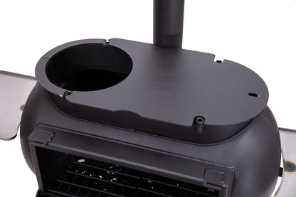 Close-up of a black metal wood stove—such as the Ozpig Big Pig—by Ozpig, featuring a closed top surface with a circular cutout and an upward-extending pipe. The stove’s front door and interior grates are partially visible, and it can be easily upgraded for versatile outdoor cooking with the Ozpig Big Pig Oven Smoker Adapter.