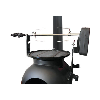 The Ozpig Series 2 Rotisserie Kit by Ozpig features a sturdy black metal rotisserie attachment with a grill plate mounted atop a round outdoor stove. The spit rod, equipped with a handle at one end and supported by durable brackets, is driven by a robust rotisserie motor housed on one side to ensure smooth, even rotation for perfect cooking results. Specially designed as part of the Ozpig Rotisserie Kit range, this setup is ideal for adding rich, wood-fired flavor to your meals. Shown here on a white