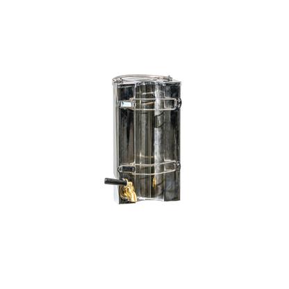 The Ozpig Traveller Kettle by Ozpig, crafted from stainless steel and featuring a transparent lid, side latches, and a brass spout handle near the bottom—mirroring the durable design of classic kettles—is shown isolated on a white background.