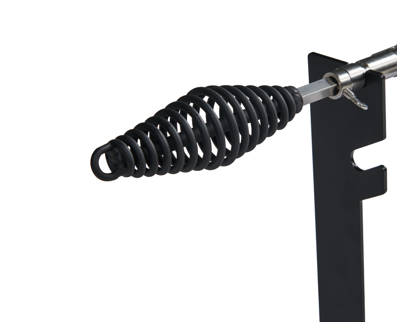 A close-up of a metal soldering iron holder with a coiled spring resting on a black metal stand, featuring the sturdy, functional design reminiscent of the Ozpig Traveller Rotisserie Kit by Ozpig, against a white background.